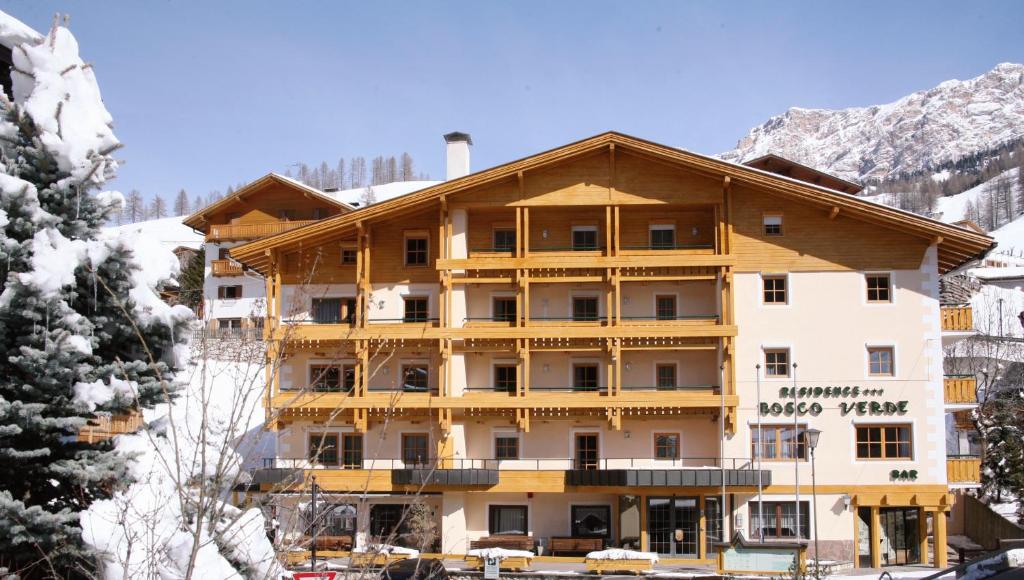 un grande edificio in montagna con neve di Residence Bosco Verde a San Cassiano