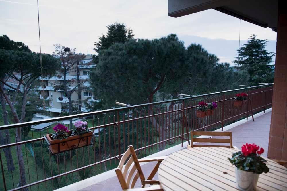 un balcone con due sedie in legno e fiori di Green view apartment a Roma
