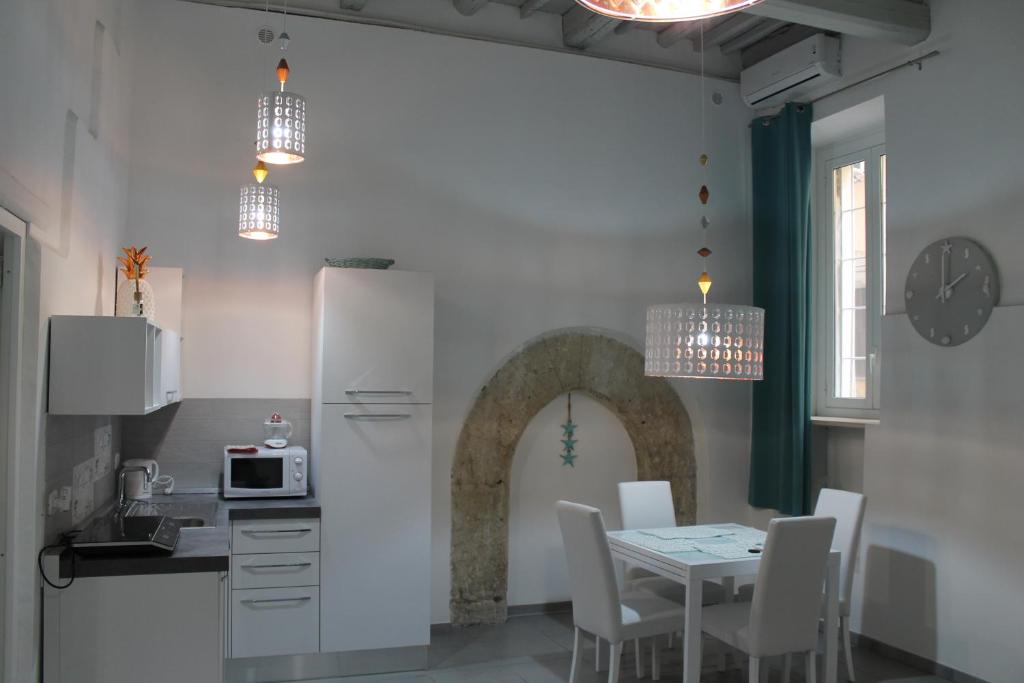 シラクーサにあるLa Corte di Aretusaのキッチン(テーブル、白い冷蔵庫付)