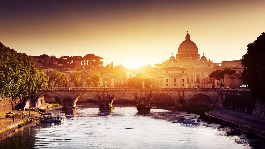 eine Brücke über einen Fluss vor einem Gebäude in der Unterkunft Sweetdreams Inn in Rom