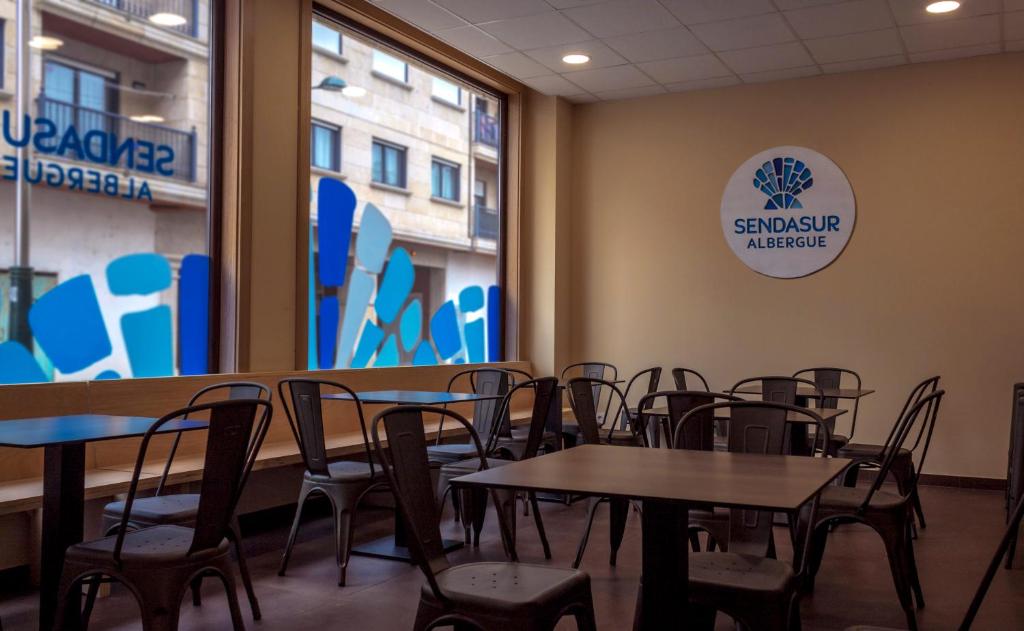 une salle à manger avec des tables et des chaises ainsi qu'une fenêtre dans l'établissement Senda Sur, à O Porriño