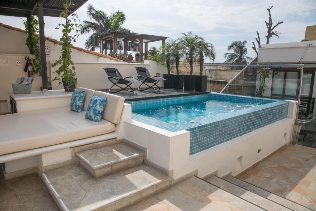 a large swimming pool with a couch and a couchituresitures at Casa Gastelbondo in Cartagena de Indias