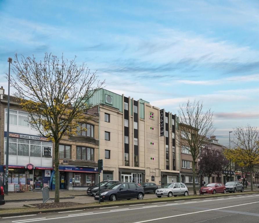 eine Straße mit Autos, die vor einem Gebäude geparkt sind in der Unterkunft Hotel Expo in Brüssel