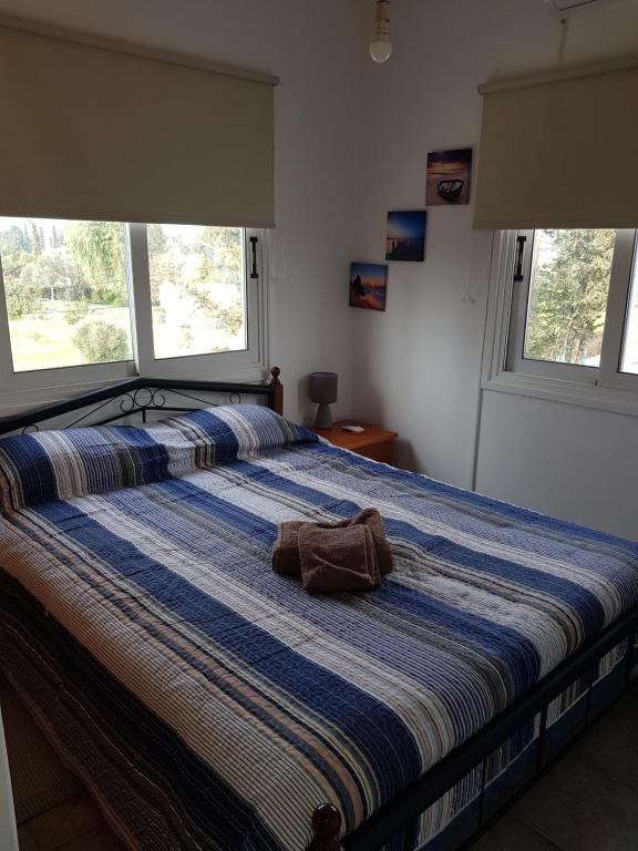 Una cama con una toalla y dos ventanas. en Strovolos rooms Studios, en Nicosia