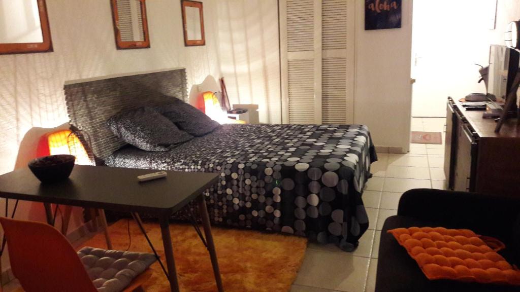 Un dormitorio con una cama y una mesa. en Bonheur à la résidence Savane, en Le Gosier