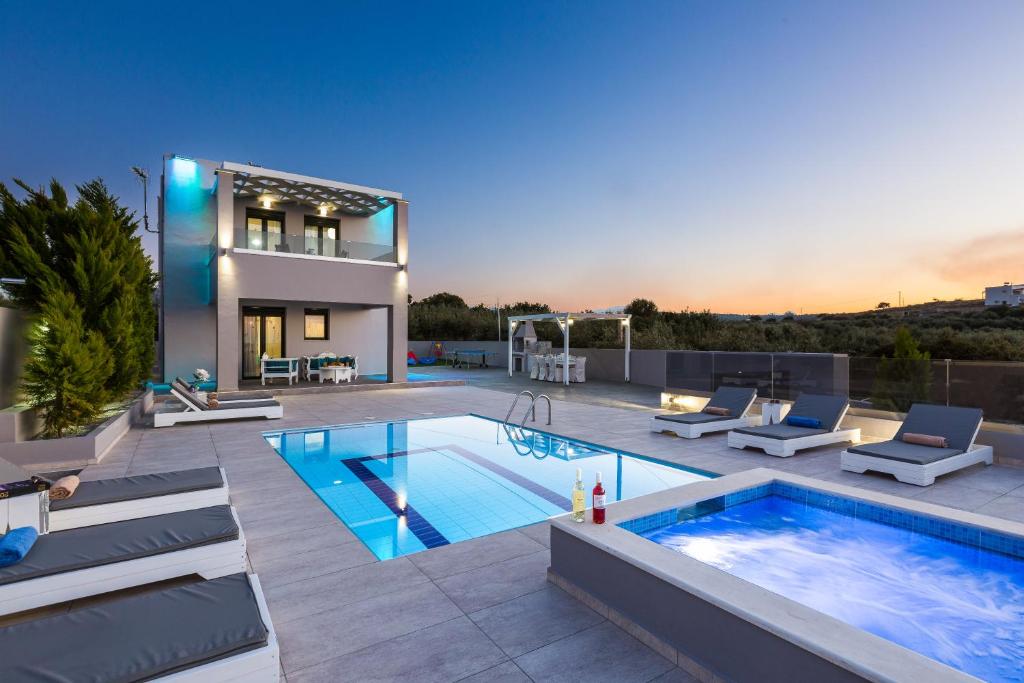 a villa with a swimming pool and a house at Evangelos Villas, lavish touch, By ThinkVilla in Angeliana