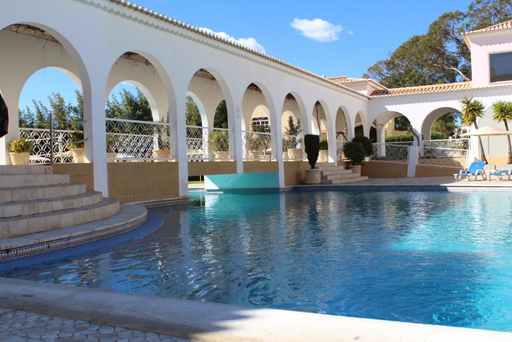 una piscina en una villa con una piscina de uso compartido en ApartamentoSolPraia - VilaRosa, en Portimão