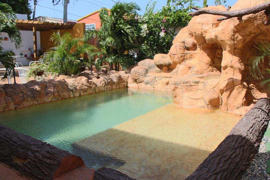 una piscina en un complejo con una pared de roca en Hospedaje Solymar Sarie Bay, en San Andrés