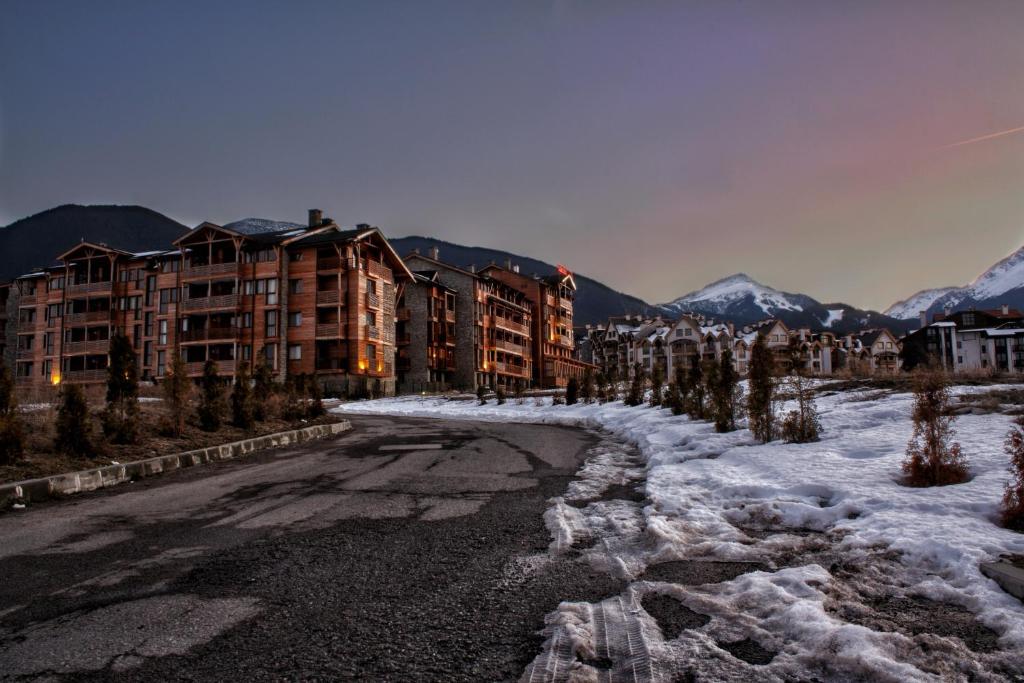 una calle cubierta de nieve frente a algunos edificios en Saint Ivan Ski Apartments, en Bansko