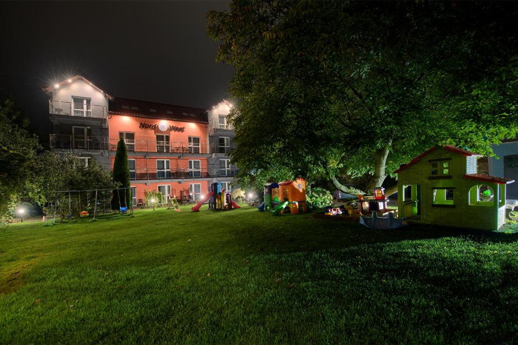 un parque de noche con un edificio al fondo en Nord-West, en Ustronie Morskie