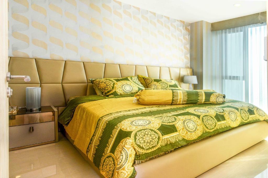 a bedroom with a bed with a yellow and green bedspread at Lux SL Luxury Style of Life 3 in North Pattaya