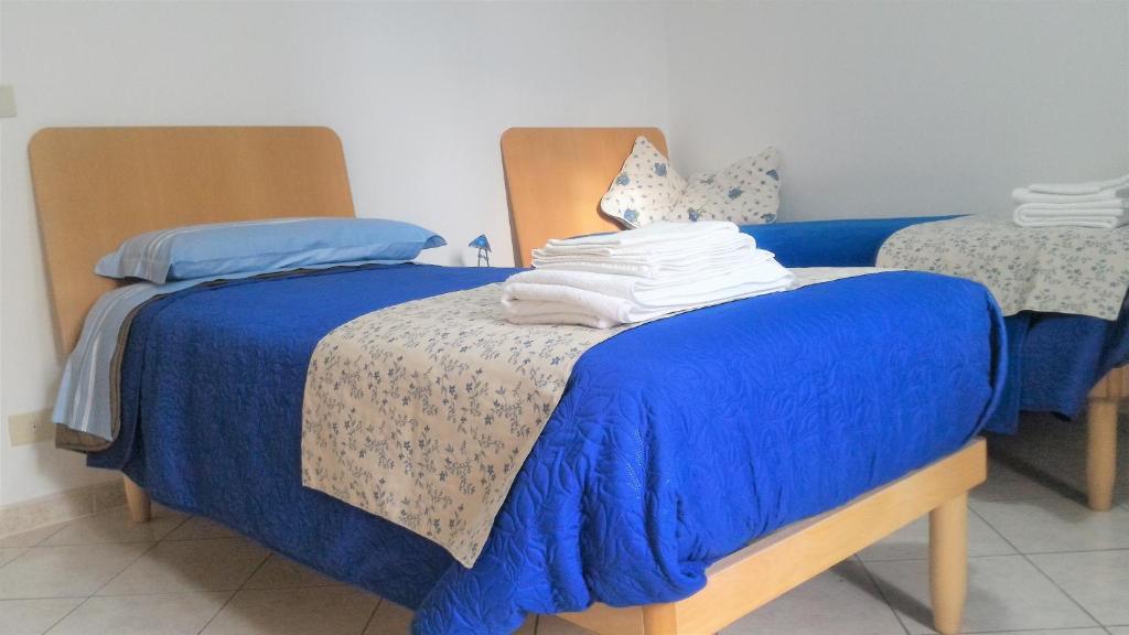 カルデラーラ・ディ・レーノにあるB&B Il Borghettoのベッドルーム1室(青い掛け布団付きのベッド1台付)