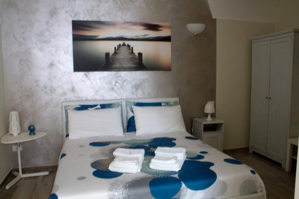 a bedroom with a blue and white bed with towels on it at Welcome Dimora in Polignano a Mare