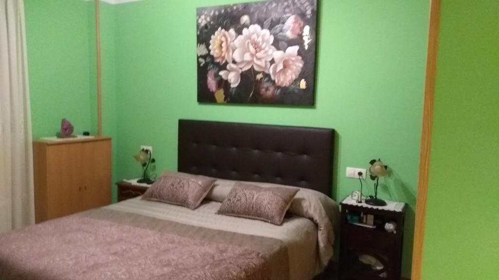 カンガス・デ・オニスにあるApartamento El Ponguetuのベッドルーム1室(ベッド1台付)が備わります。壁には絵画が飾られています。