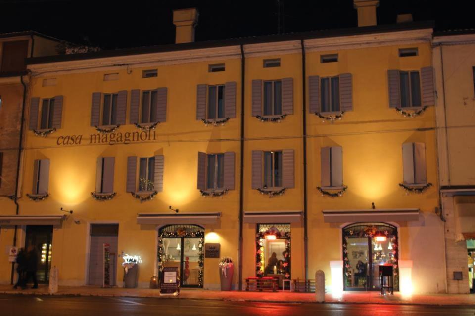 un grande edificio giallo con finestre su strada di Hotel Casa Magagnoli a Finale Emilia
