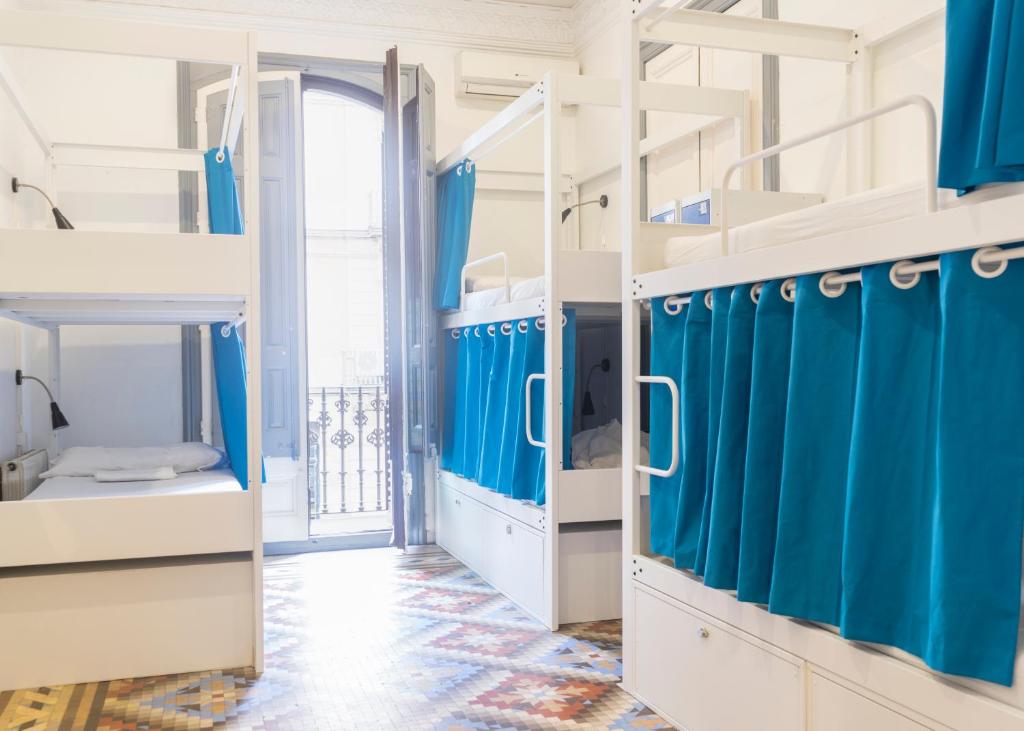 バルセロナにあるソウル バックパッカーズ バルセロナの青と白の二段ベッドが備わる客室です。