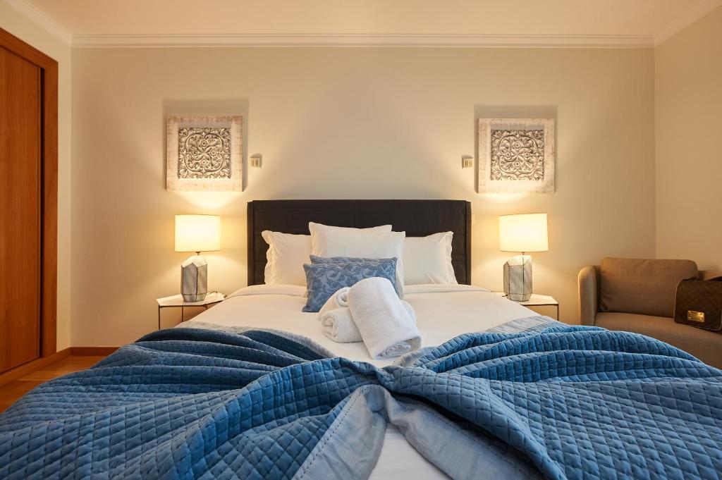 カスカイスにあるBeGuest Arribamar Apartmentのベッドルーム1室(大型ベッド1台、青い毛布、枕付)