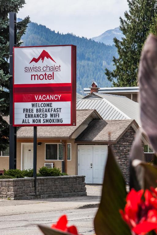 a sign for a motel in front of a house at Swiss Chalet Motel in Revelstoke