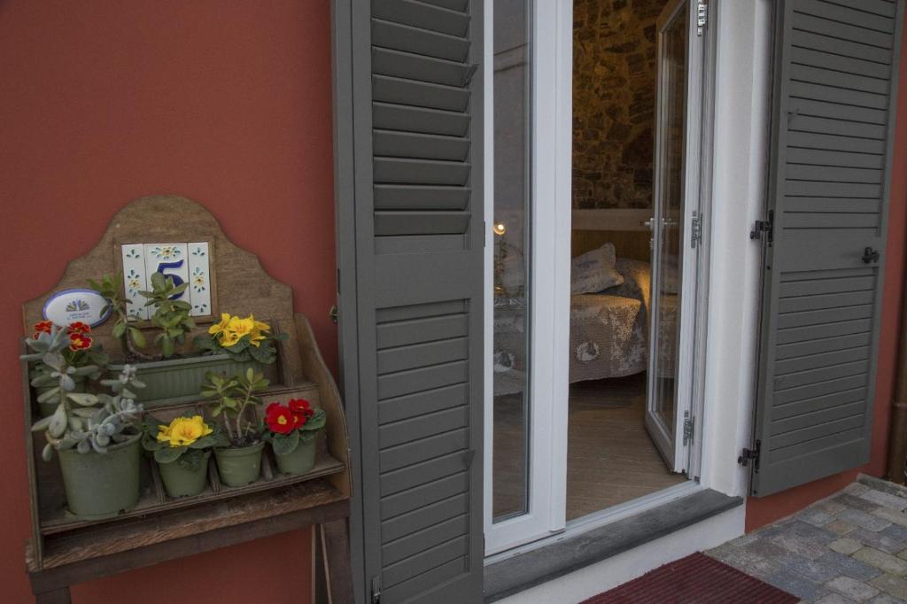 an open door with potted flowers on a window sill at La corte dei tre in Torre del Lago Puccini