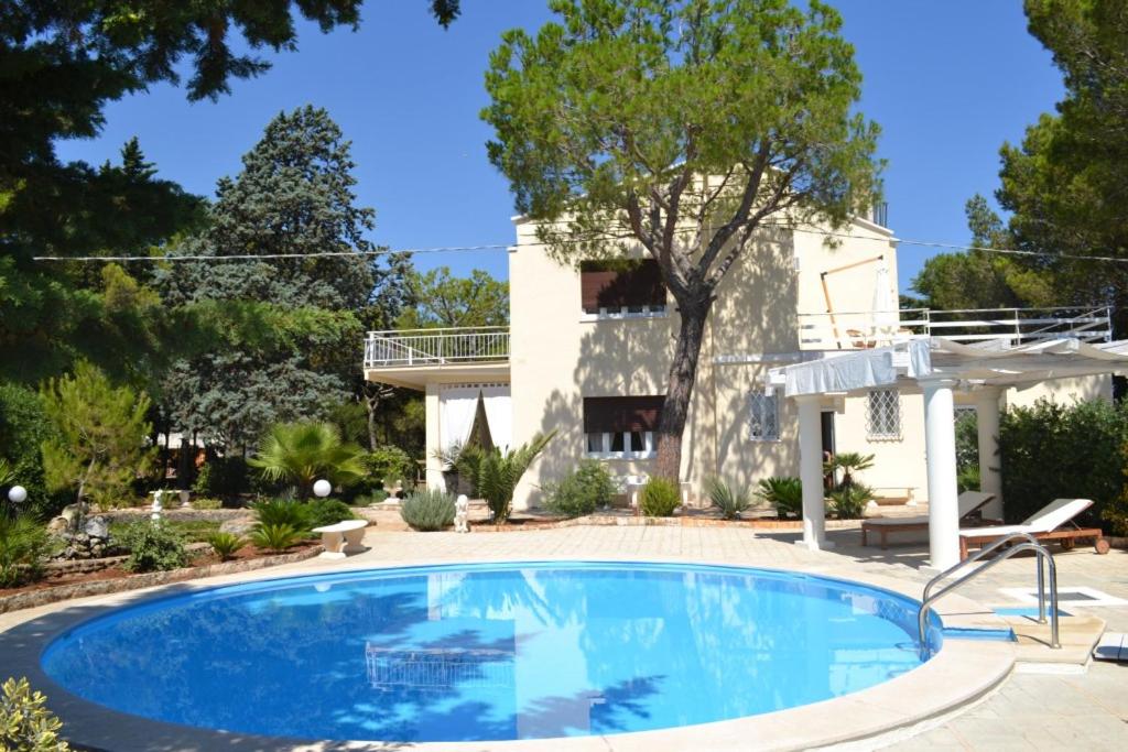 une piscine devant une maison dans l'établissement Villa panoramica con piscina, à Fasano