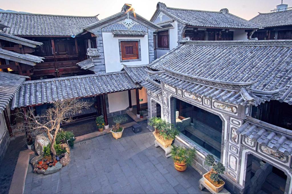 an overhead view of an asian building with plants at Shaxi Aoding Courtyard in Jianchuan