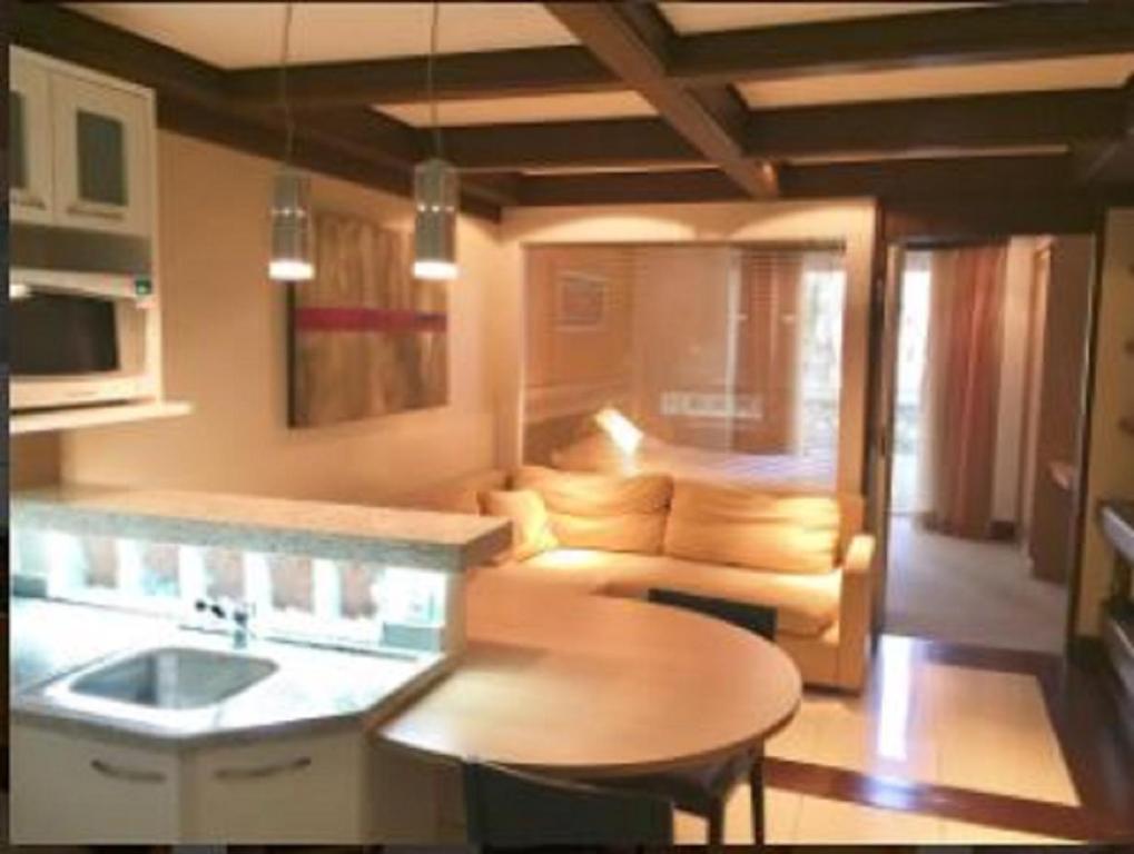cocina y sala de estar con sofá y mesa en Lindo Studio no Mountain Village, en Canela