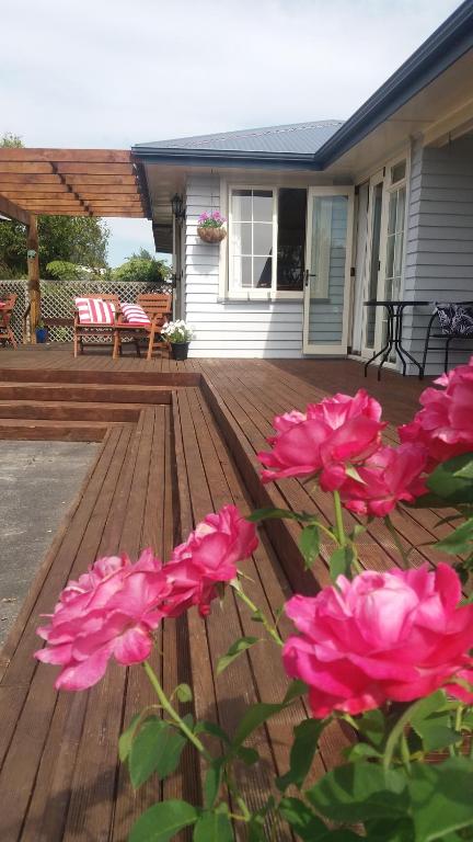 a bunch of pink flowers on a wooden deck at Scottbase B and B in Feilding