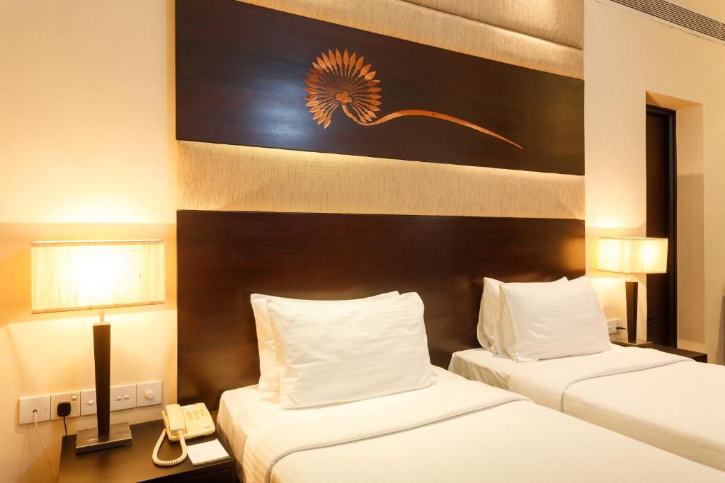 Postel nebo postele na pokoji v ubytování Renuka City Hotel