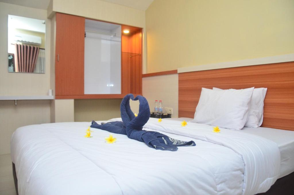 a bed with a stuffed animal sitting on top of it at Banyu Homestay in Banyuwangi