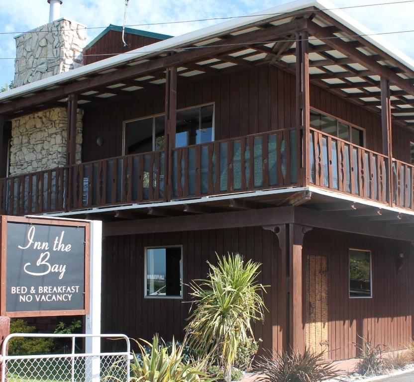 a wooden building with a balcony on top of it at Inn the Bay Bed & Breakfast in Kaikoura