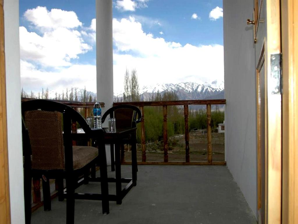 a balcony with a table and chairs and a view at Hotel Ladakh Heaven in Leh