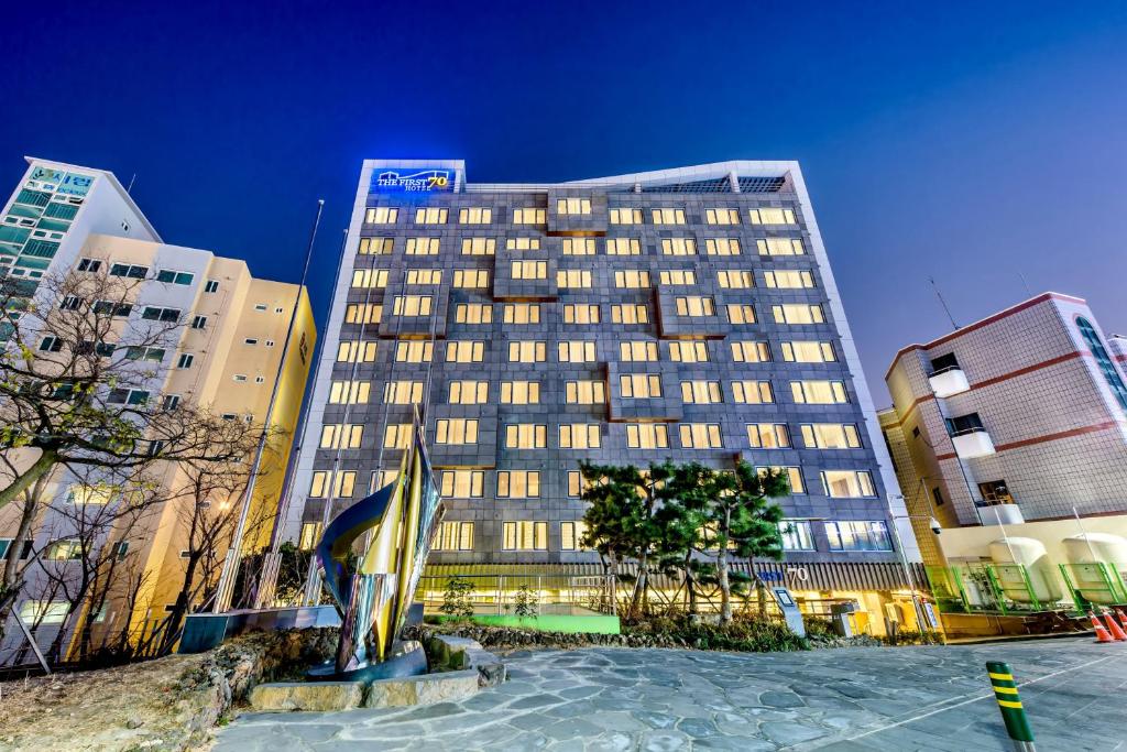 a tall building in a city at night at The First70 Hotel in Seogwipo