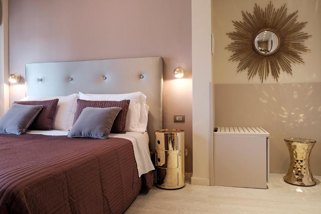 a bedroom with a large bed and a mirror at Hotel Corso Alaxi Hotels in Alassio