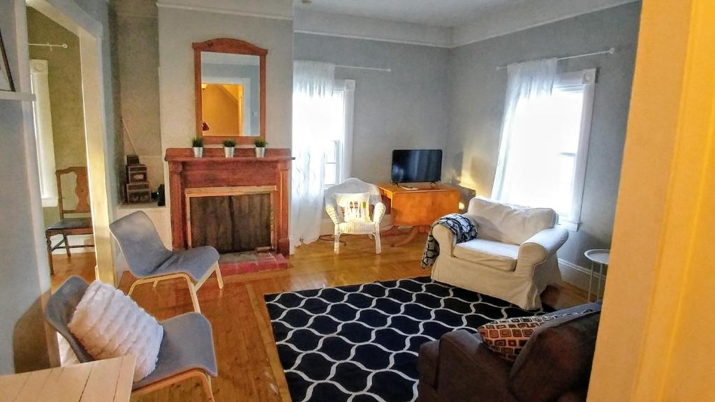 a living room with chairs and a fireplace at Beside The Tulip Tree in Shelburne