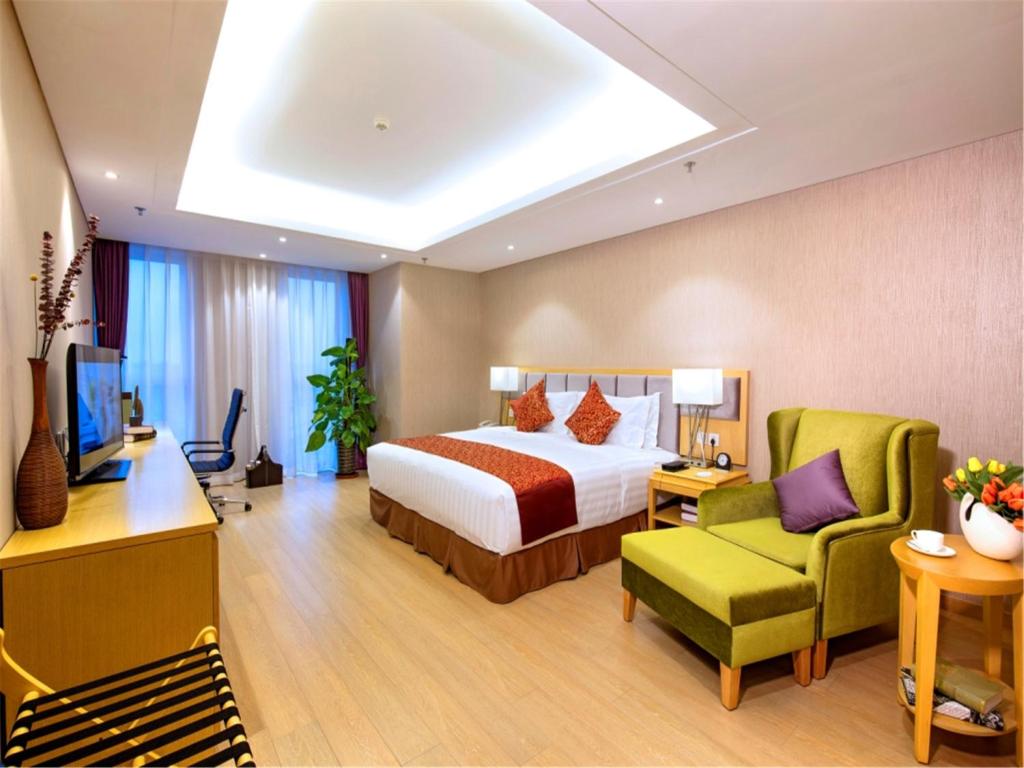 a hotel room with a bed and a green chair at Ariva Tianjin Zhongbei Hotel & Serviced Apartment in Tianjin