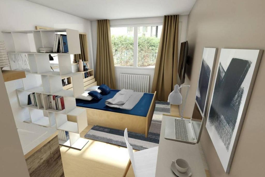 Cette petite chambre comprend un lit et un bureau avec un ordinateur portable. dans l'établissement Studio Gare Metz Côté Cour, à Metz