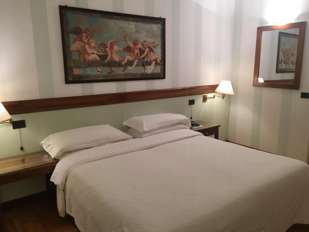 sypialnia z białym łóżkiem i obrazem na ścianie w obiekcie hotel alla busa w mieście Noventa Vicentina