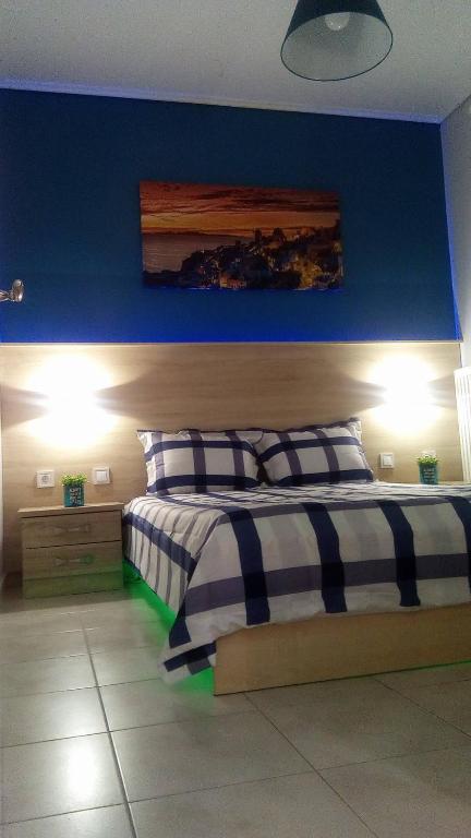 a bedroom with a bed with a blue wall at Amazing Apartment In The Center in Alexandroupoli