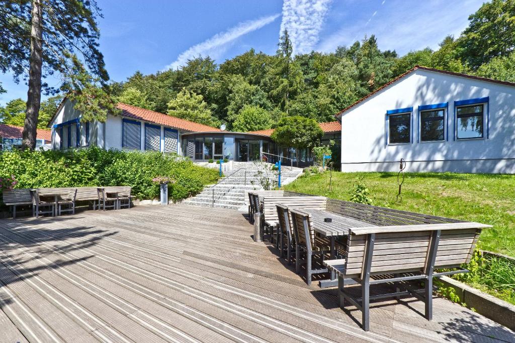 a wooden deck with benches and a building at SeminarZentrum Rückersbach in Johannesberg