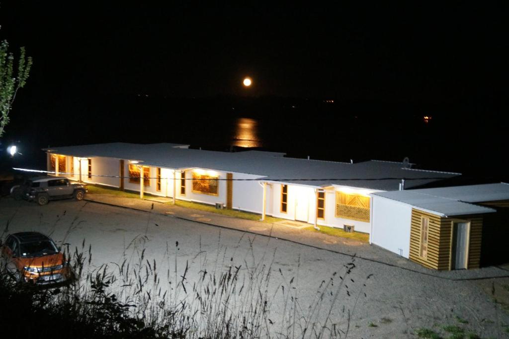 un edificio bianco con luci accese di notte di Mangata Hotel Low Cost a Castro