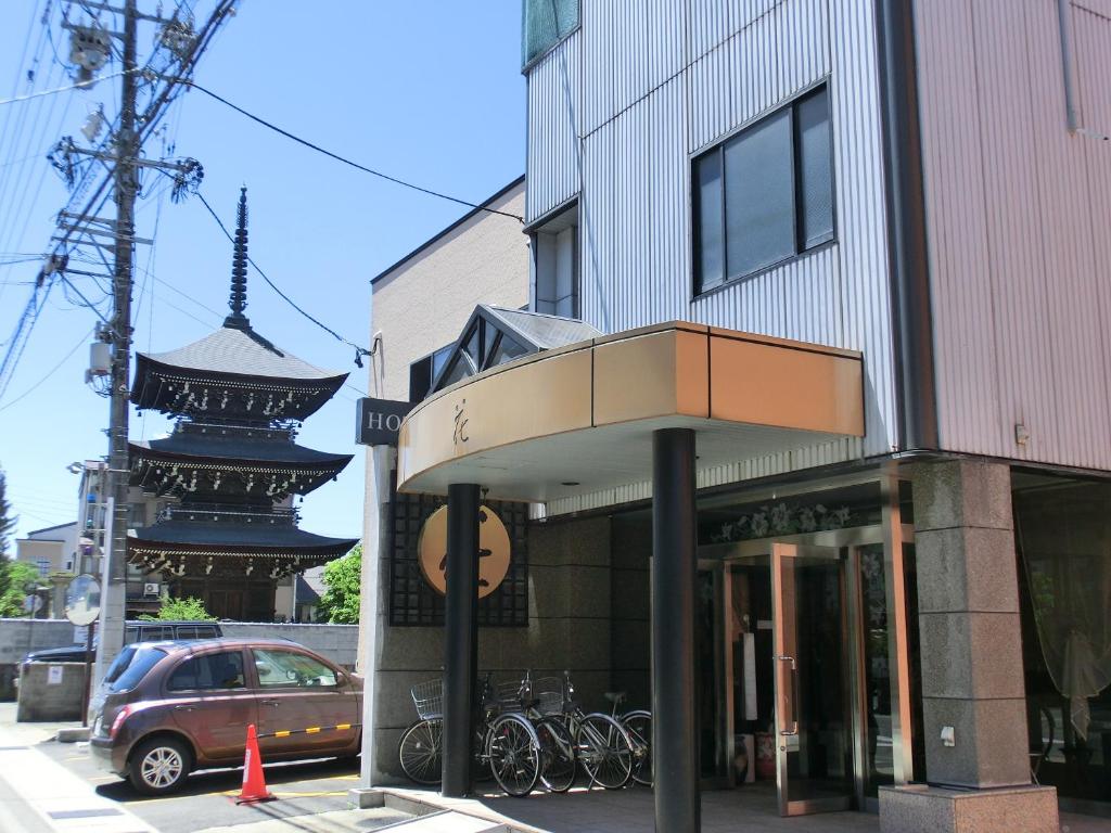 a building with a balcony on the side of a street at Hotel Hana in Takayama