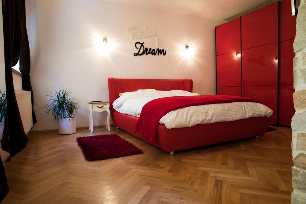 - une chambre avec un lit doté d'une tête de lit rouge dans l'établissement Luky10, à Braşov