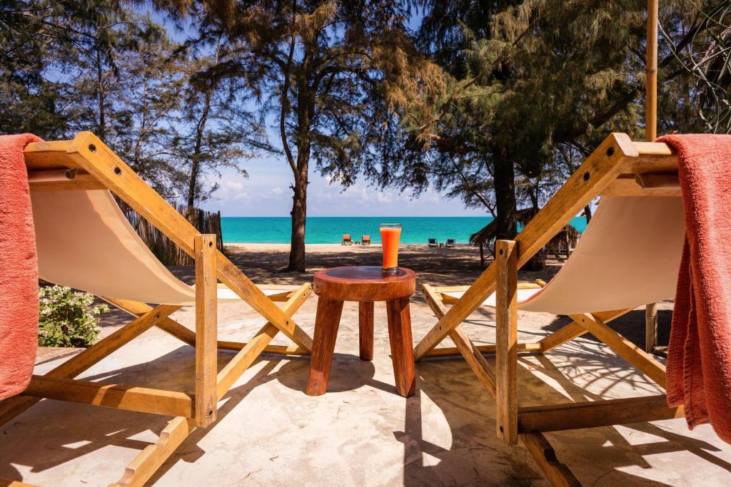 Mumsa Beach Resort & Restaurant في بانهوايْ يانغْ: طاولة وكراسي على شاطئ مع المحيط