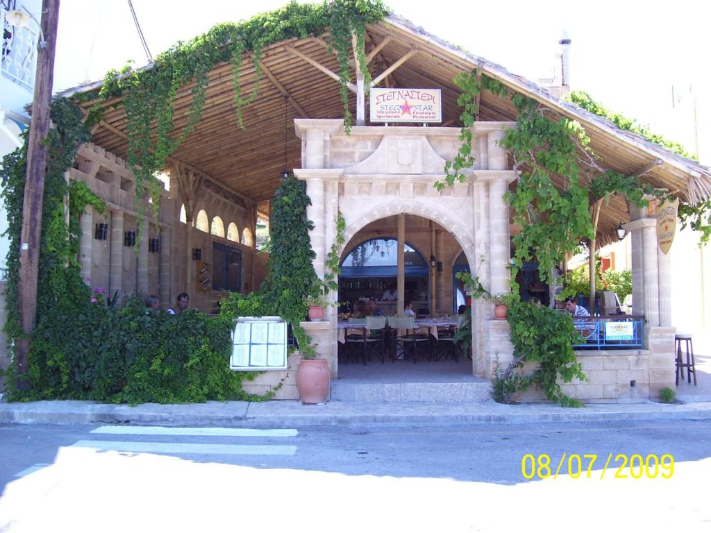 a building with an archway with tables in it at Stegna Star Apartments in Archangelos