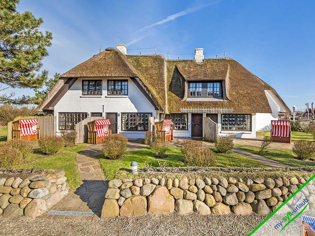 a large white house with a thatched roof at Landhaus Meer in Kampen