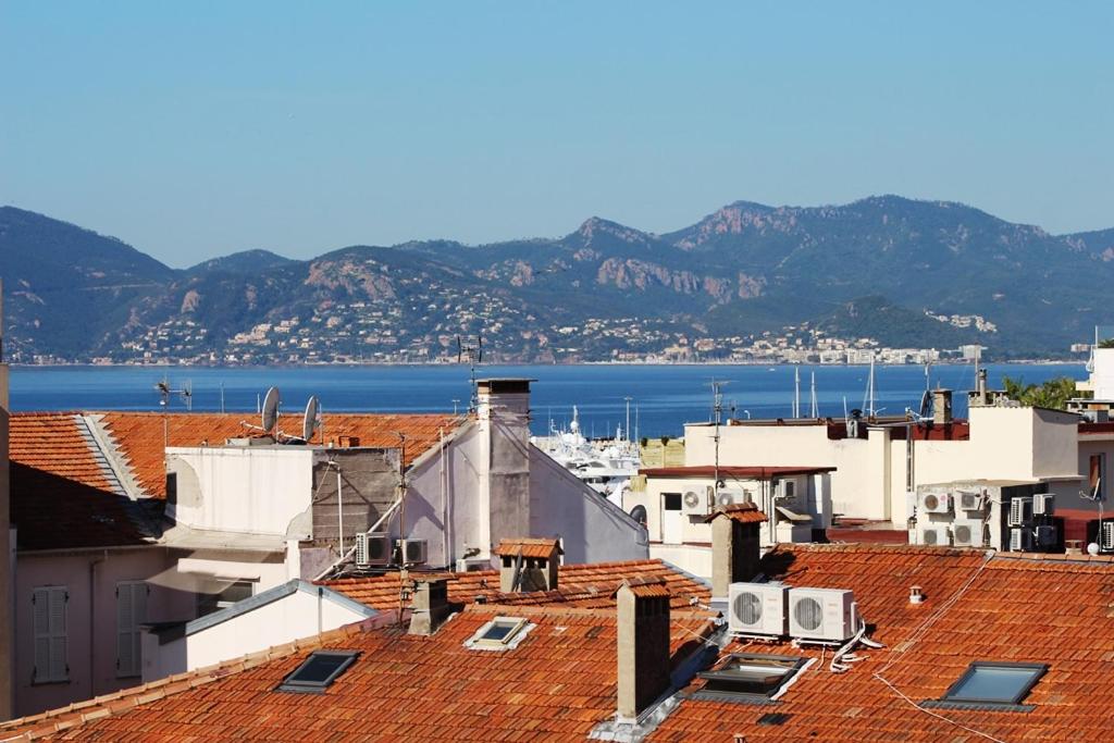 - une vue sur les toits des bâtiments et l'eau dans l'établissement Le Grand Hotel, à Cannes