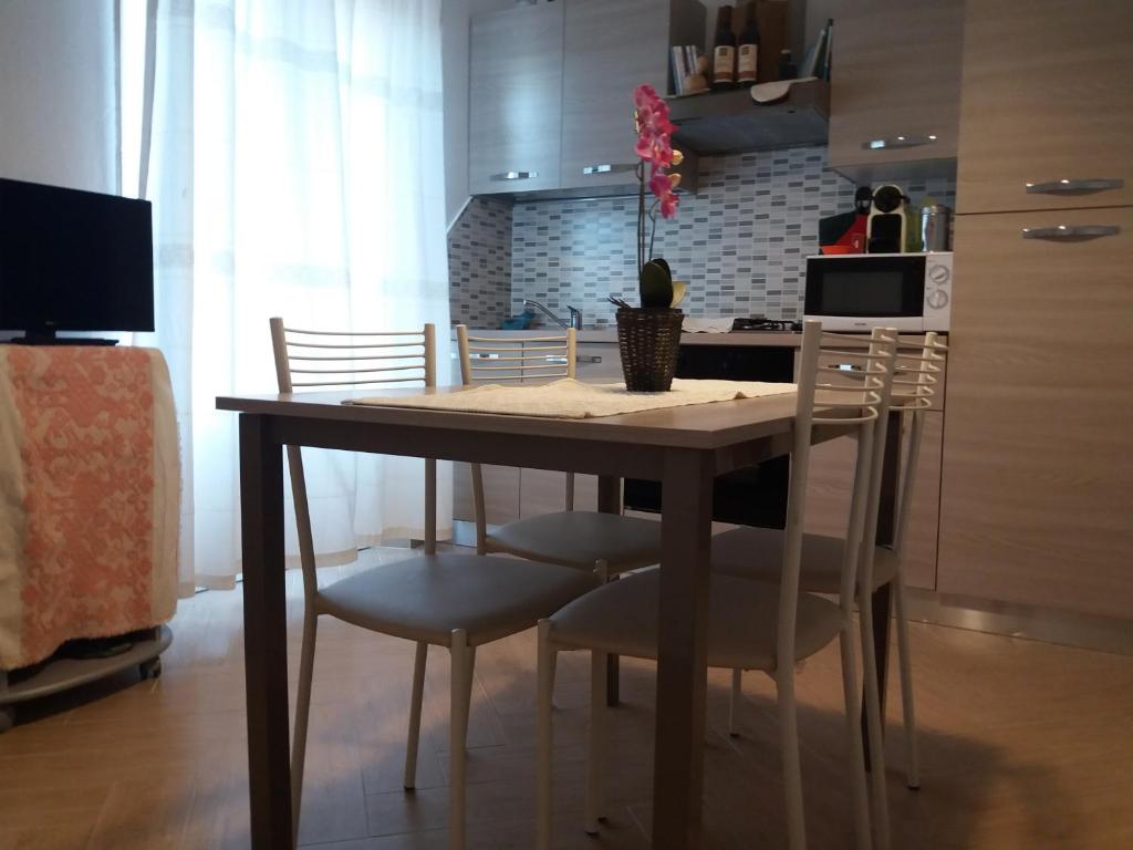 アルツァケーナにあるAppartamento Casa Ilariaのダイニングルーム(テーブル、椅子付)、キッチン