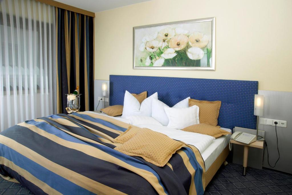 a bedroom with a large bed with a blue headboard at Hotel Löwen-Seckenheim in Mannheim