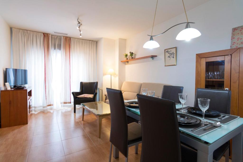 a dining room and living room with a table and chairs at Apartamento Cifuentes in Granada