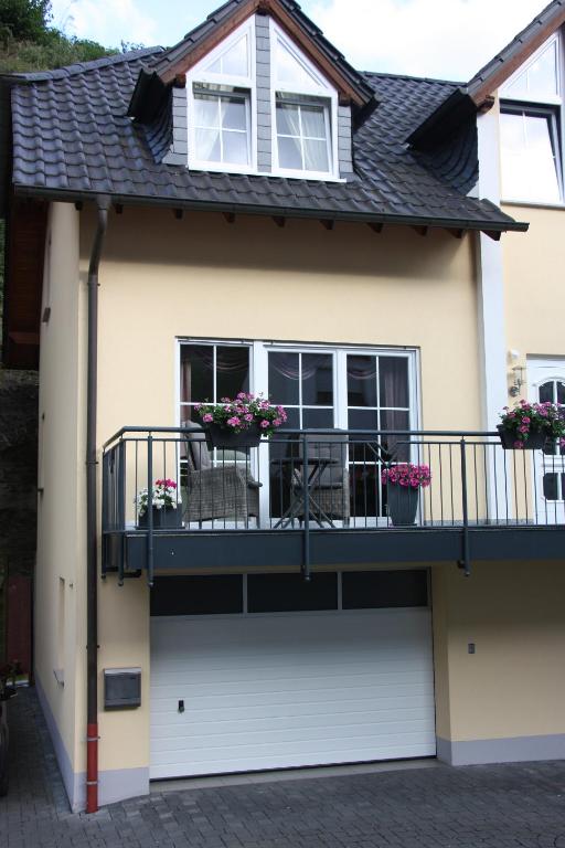 a house with a balcony with flowers on it at Fewo-am-Rotheschbach in Zell an der Mosel
